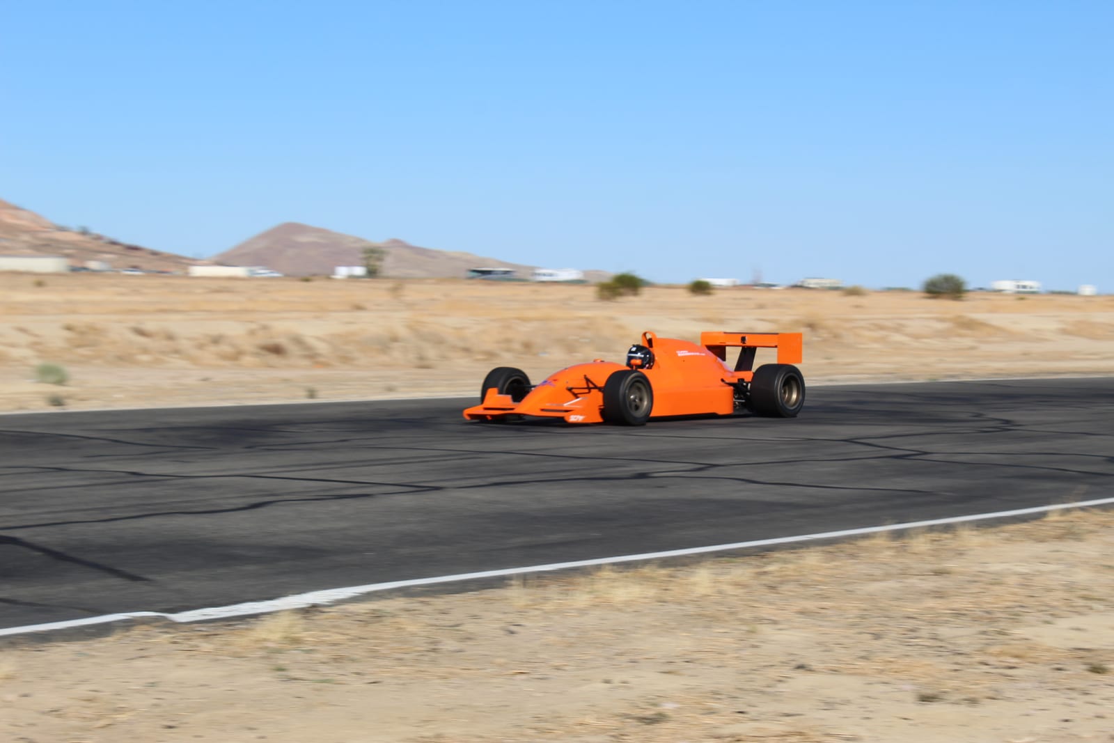 A FastLane Lola T93/20 Indy Lights open-wheel car on track at Buttonwillow Raceway Park.