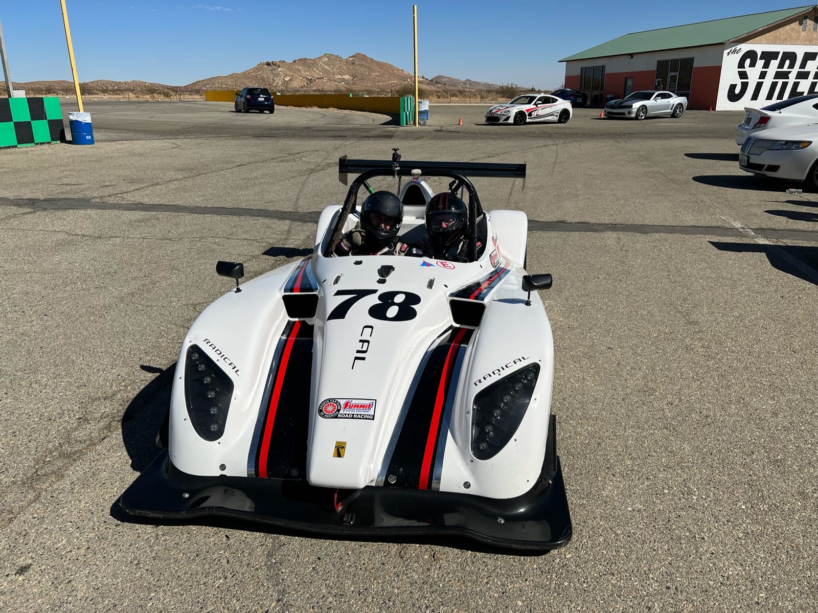 A white FastLane Radical SR1 sports racer staged on track at Buttonwillow Raceway.