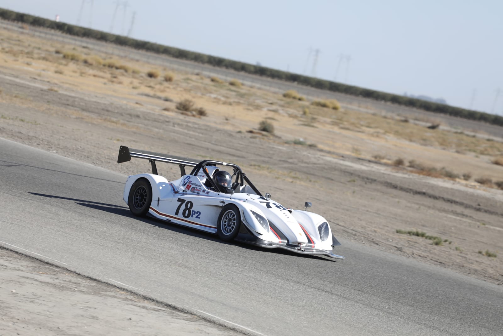 A white FastLane Radical SR3 sports racer at speed on track at Buttonwillow Raceway.