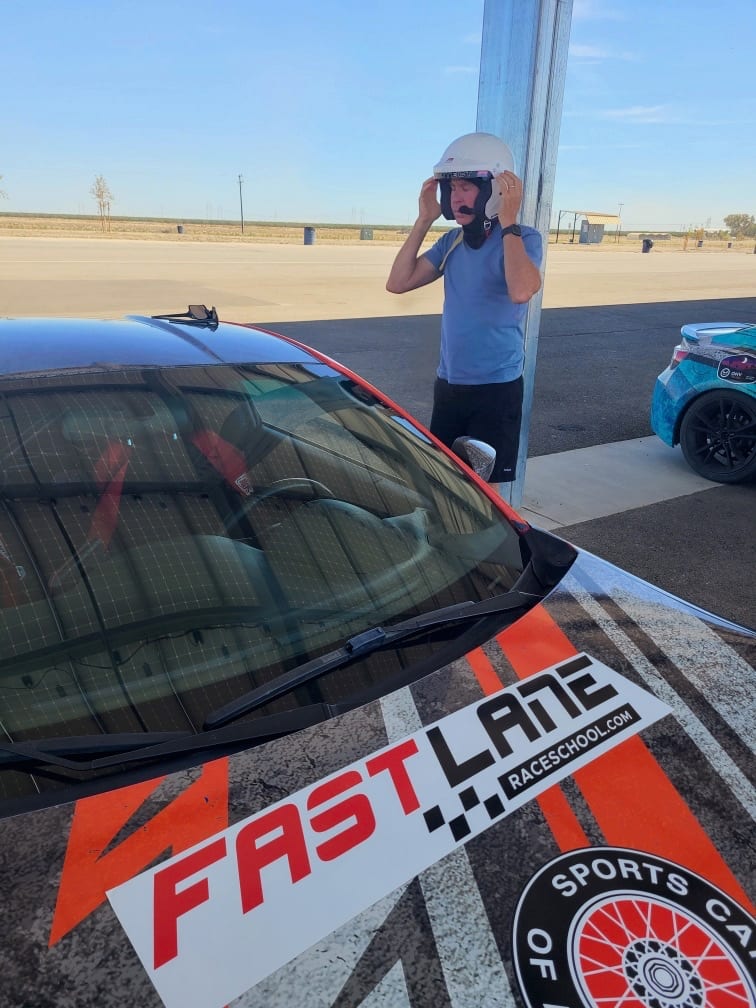 A helmeted FastLane student driver ready to head out on track at Buttonwillow.